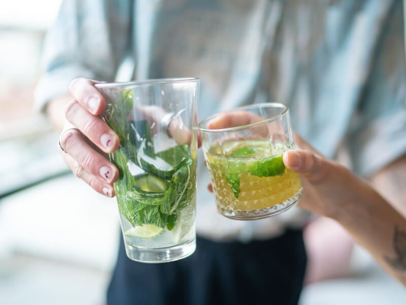 Hands clinking cocktail glasses together
